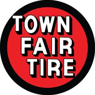 A red and black circular logo with the words “Town Fair Tire” in bold white letters at the center, evoking the precision found in Engineered Systems Inc’s innovative MEP/FP designs.